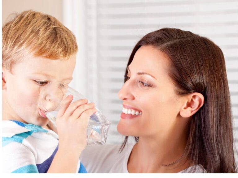 Matka z dzieckiem pija wodę. Obrazek w artykule Ile pić wody na kg? Poradnik dla zdrowego nawodnienia