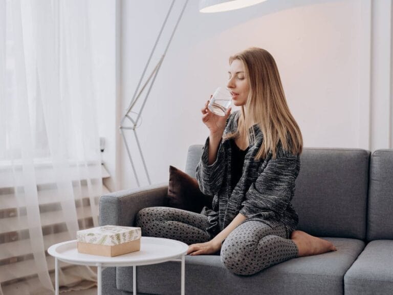 Długowłosa dziewczyna z wodą. Obrazek w artykule Ile pić wody dziennie? Wzór i zasady