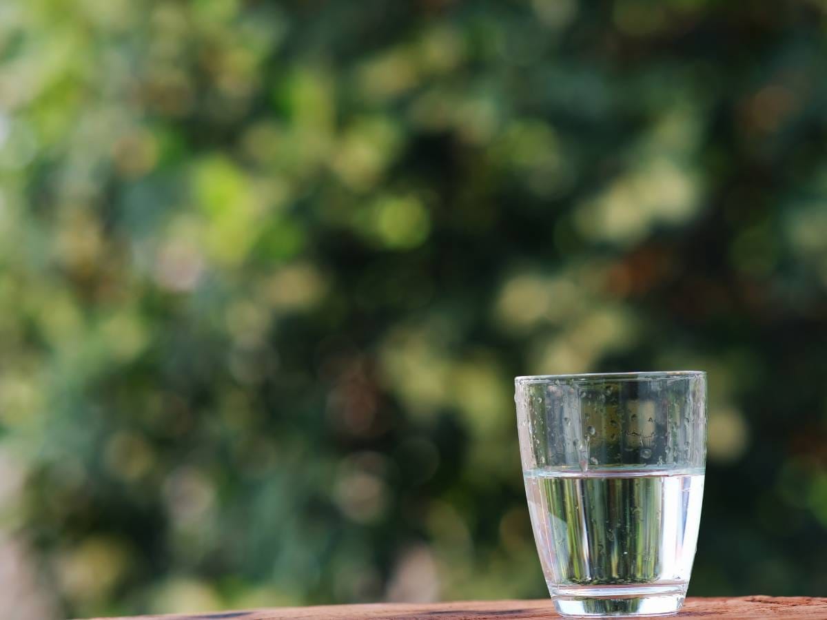 Szklanka z wodą na tle okna. Obrazek w artykule Ile to 300 ml? Poznaj dokładną objętość w mililitrach.